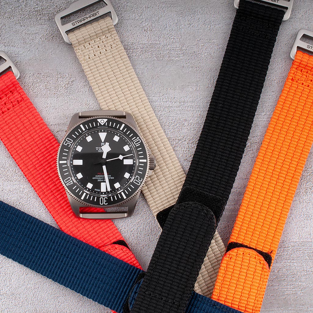 Hook-and-loop single-pass watch straps in red, khaki, black, navy, and orange with Tudor diver on khaki strap
