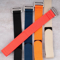 Hook-and-loop single-pass watch straps in black, navy, orange, khaki, and red with red strap crossed over, showing texture